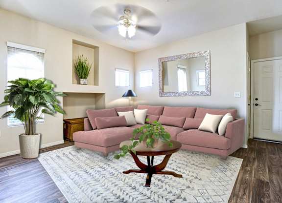 A living room with a pink couch and a ceiling fan.