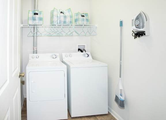 A white washing machine and dryer in a small laundry room.