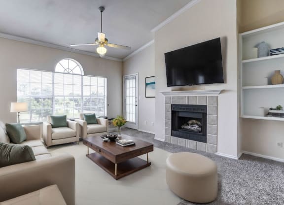 Light and bright living rooms with built in book shelves, large windows and fireplaces at Turnberry Isle Apartments in Dallas, TX.