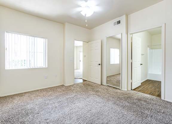 A spacious room with a carpeted floor and white walls.