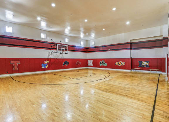 the gym is equipped with a basketball court and hardwood floors