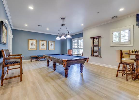 A room with a pool table and a chair.