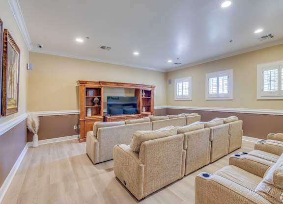 A living room with a row of couches and a bookcase.