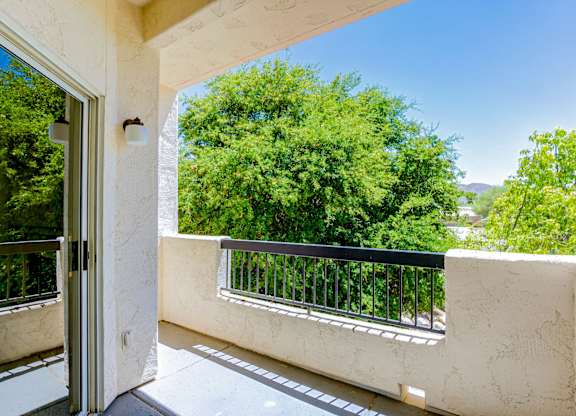 A balcony with a black railing and a glass door.