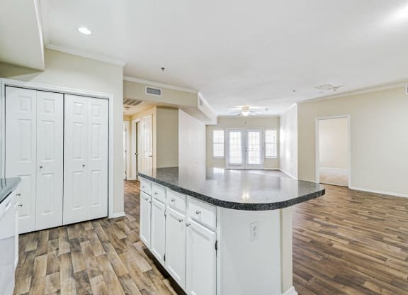 an empty kitchen with white cabinets and a counter top