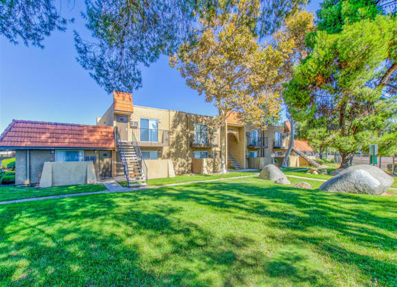 Exterior of apartment with a recreation area and large trees at Woodlake, Escondido, CA