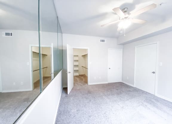 Spacious bedroom with walk in closet at Tuscany Square Apartments in North Dallas, TX. Now leasing studios, 1 and 2 bedroom apartments.