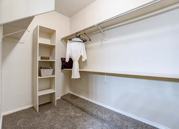A white shirt is hanging on a clothes rack in a room.