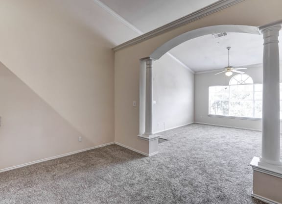 Large and bright living rooms with archways at Turnberry Isle Apartments in Dallas, TX.