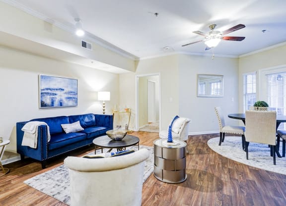 a living room with a blue couch and a ceiling fan
