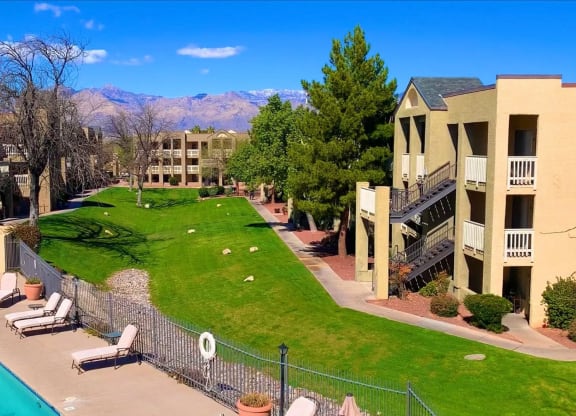 an aerial view of a yard with a pool and apartment buildings