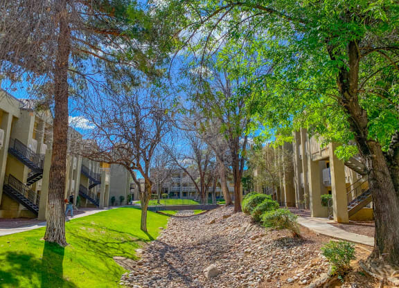 a view of a courtyard with trees and buildings