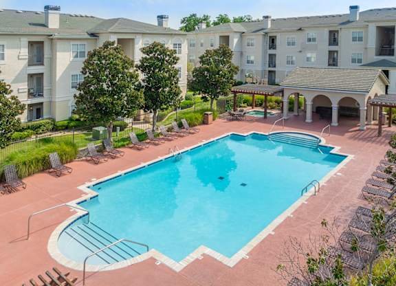 A large swimming pool surrounded by apartment buildings.