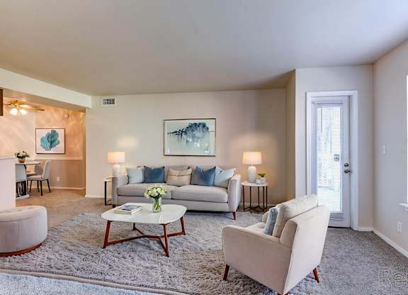 A living room with a white couch, a coffee table, and a painting on the wall.