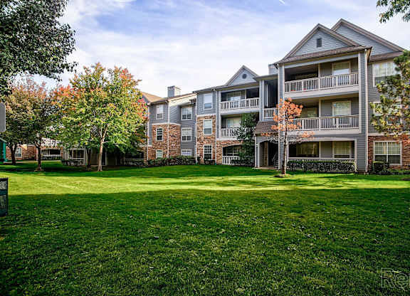 A large grassy area in front of apartment buildings.