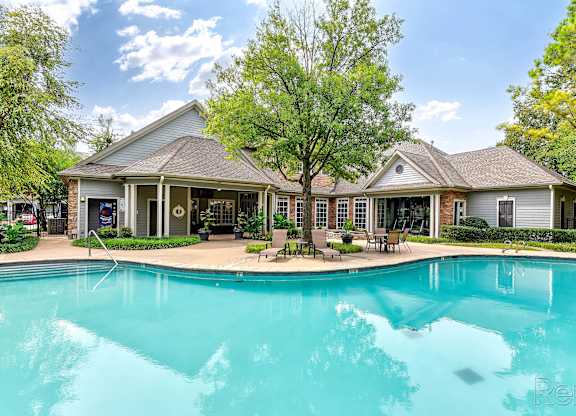 A large house with a pool in front.
