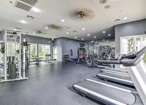 A spacious gym with treadmills, weights, and other exercise equipment.