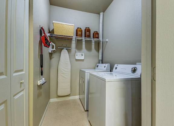 A laundry room with a washer and dryer, a towel, and some shelves.