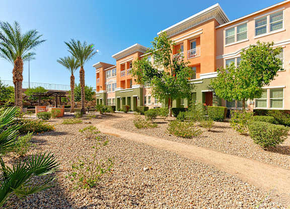 A sunny day at a residential area with apartment buildings and palm trees.