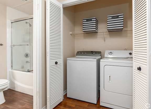 A white toilet is in a bathroom next to a white cabinet.