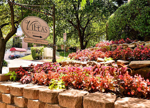 A sign that says "The Vineyards at Kate" is in front of a wall of red and green plants.