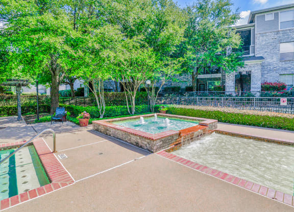 a fenced in swimming pool with trees and a building in the background