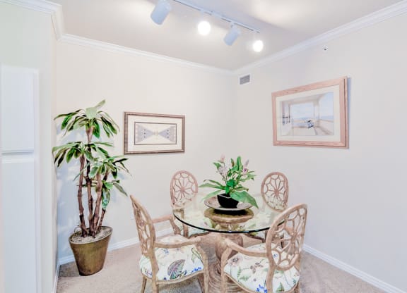 a dining room with a glass table and chairs