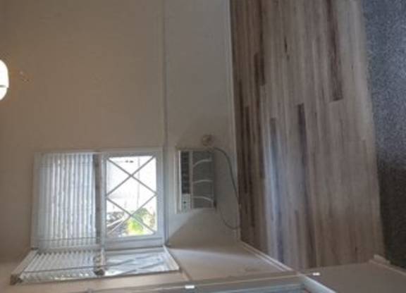 A white bathroom with a window and a shower.