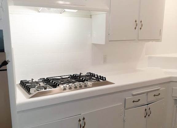 A white kitchen with a stove top oven.