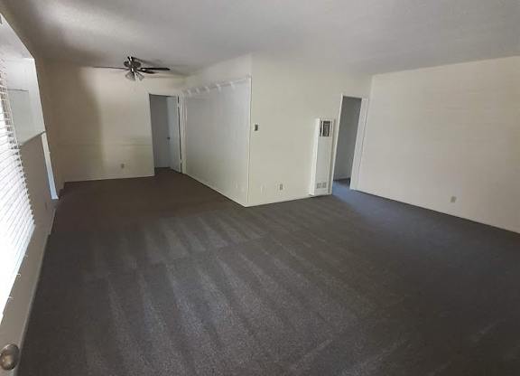 A room with a grey carpet and white walls.