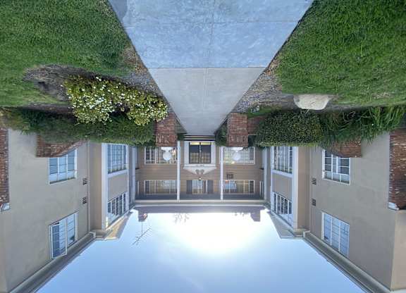A building with a green roof and a courtyard in the middle.