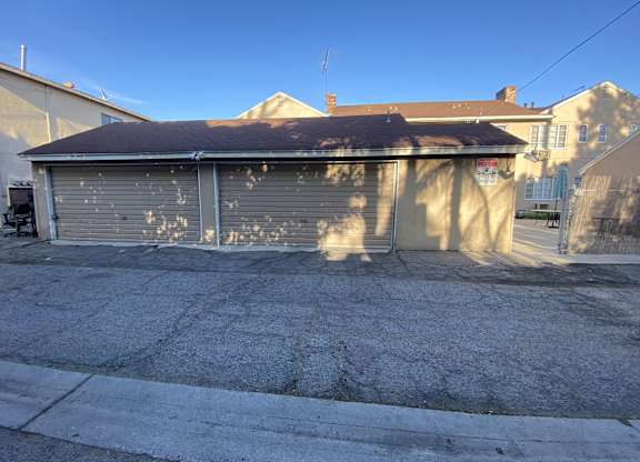 A garage with a closed grey door is in front of a house.