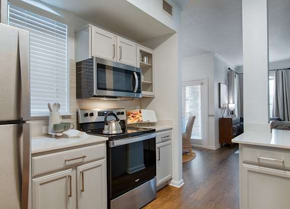 Kitchen with stainless steel appliances and white cabinets at Silverado Apartments, Frisco, TX 75034