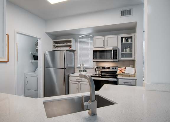 Kitchen with stainless appliances and white countertops at Silverado Apartments, Frisco, Texas