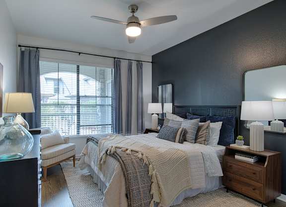 Bedroom with dark accent wall and ceiling fan at Silverado Apartments, Texas, 75034