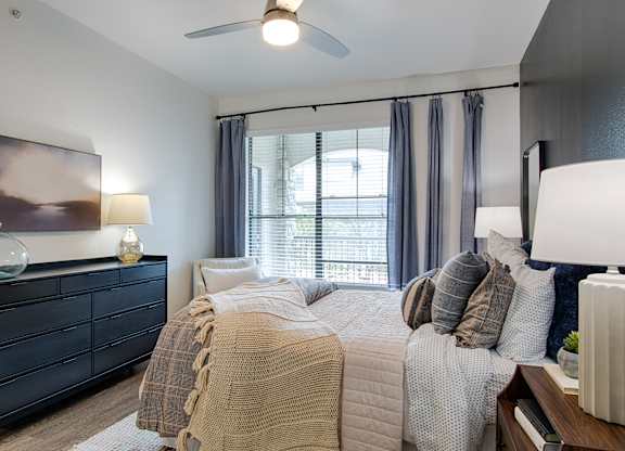 Bedroom with ceiling fan and large window at Silverado Apartments, Frisco, TX 75034