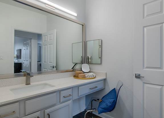 Bathroom vanity with makeup station and seating at Silverado Apartments, Frisco, 75034