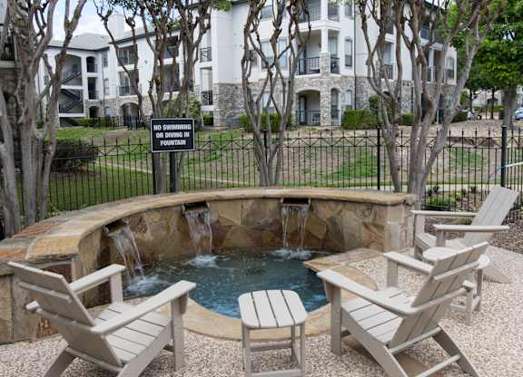 Stone fountain with waterfall and seating area at Silverado Apartments, Frisco, Texas