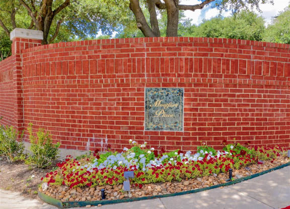 Lush front landscaping and brick façade of Montfort Place in North Dallas, TX, For Rent. Now leasing 1 and 2 bedroom apartments.