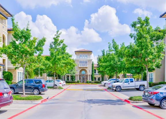 Spacious parking lot at Mission at La Villita Apartments in Irving, TX offers 1, 2 & 3 bedroom apartment homes with appliances.