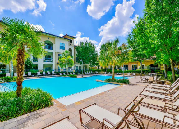 Sparkling pool with lounge chairs at Mission at La Villita Apartments in Irving, TX offers 1, 2 & 3 bedroom apartment homes with appliances.
