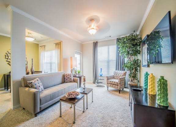 Spacious living room with bright windows at Mission at La Villita Apartments in Irving, TX offers 1, 2 & 3 bedroom apartment homes with appliances.
