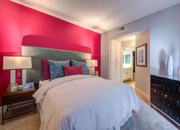 a bedroom with a large bed and a dresser in front of it