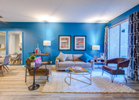 a living room with blue walls and wood floors