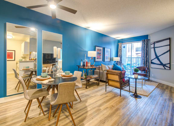 a living and dining room area with blue walls and hardwood floors
