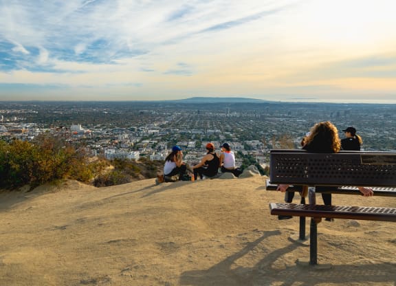 a group of people sitting on a bench on top of a hill