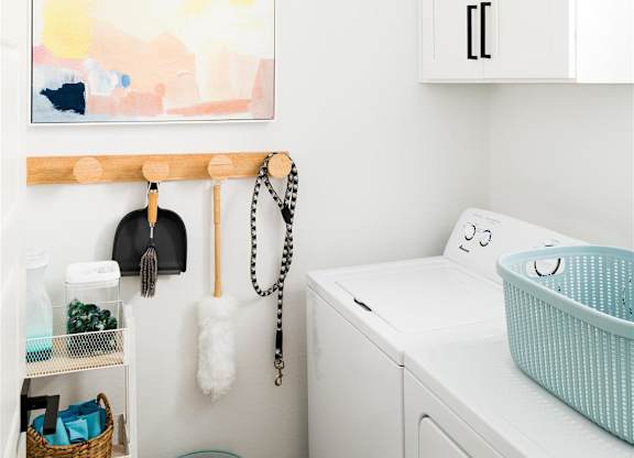 a small laundry room with a washing machine and a painting on the wall at Villas on Ash, Arizona, 85234