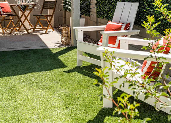 a patio with a table and chairs and a privacy hedge at Villas on Ash, Gilbert Arizona