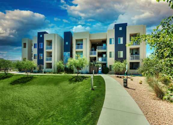 A modern apartment complex with a green lawn in front. at Craft at Gilbert and Baseline Apartments, Mesa, 85204