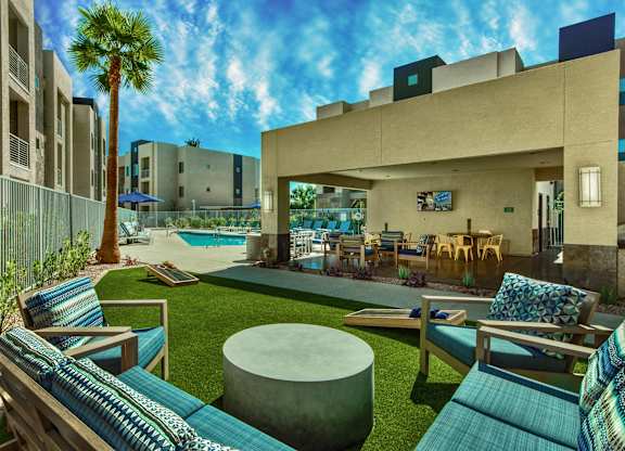 A modern outdoor seating area with a pool and palm tree at Craft at Gilbert and Baseline Apartments, Mesa, Arizona